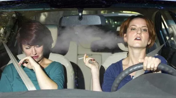 A woman smoking in a car