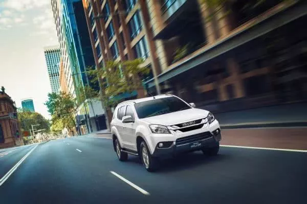 A white Isuzu MU-X on the road