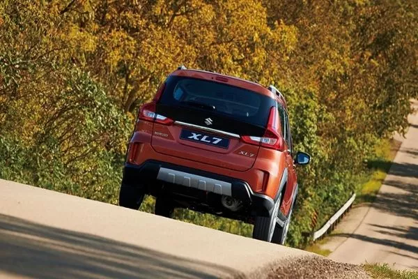 A picture of the rear of the XL7 as it drives on a road in the countryside