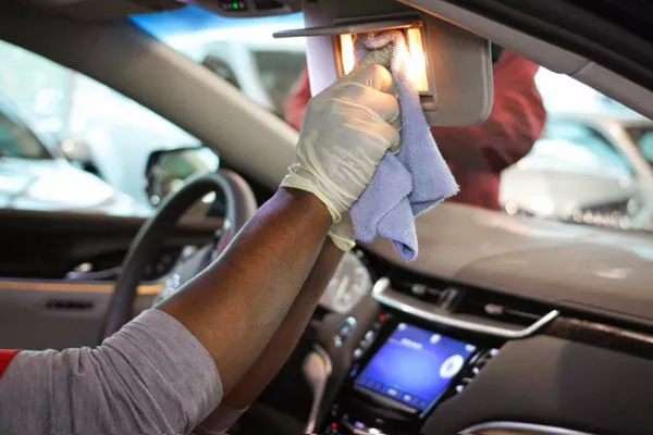 A man wearing gloves cleaning a car's windows