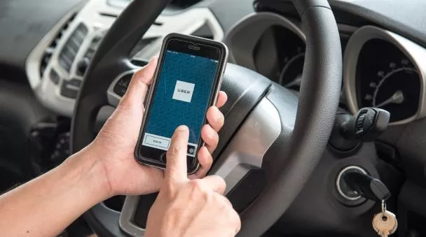 A driver is using Uber app in car