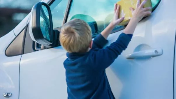 a child cleaning a car